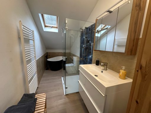 Helles, modernes Badezimmer mit Dusche, Badewanne und Waschtisch.